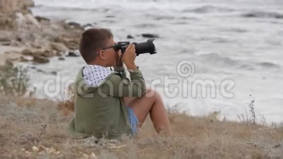海滩暑假带着相机在海滩上的男孩视频的预览图