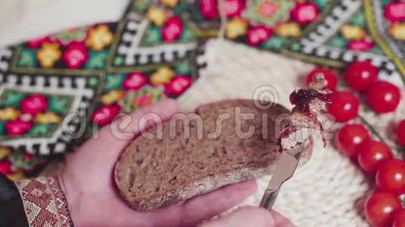 男人正在乌克兰毛巾附近铺一块新鲜的面包上面有馅饼奶酪慢动作视频的预览图