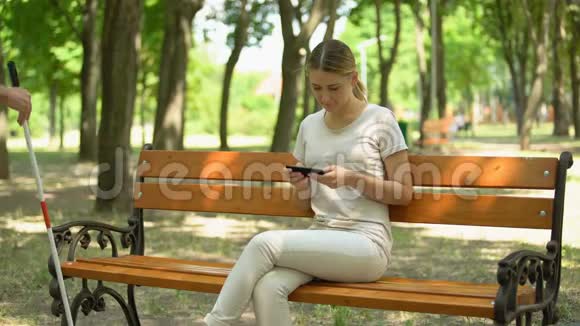 善良的女孩帮助盲人养老金领取者坐在长凳上尊重和照顾残疾人视频的预览图