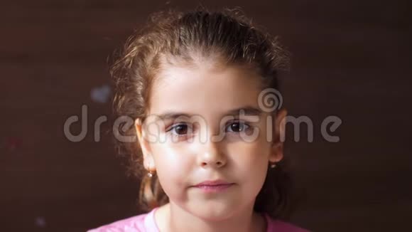 一个没有牙齿的女孩的肖像这孩子从牙齿的洞里露出舌头为了展示视频的预览图