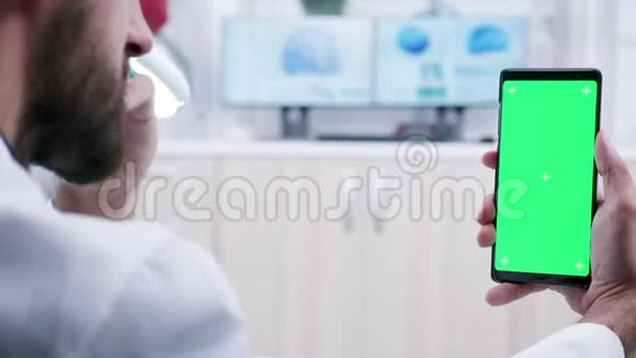 医护人员手持绿色屏幕智能手机的多利镜头视频的预览图