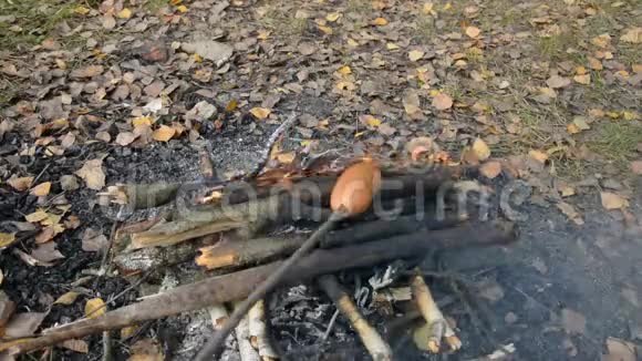 在篝火旁烤香肠露营者烤香肠视频的预览图
