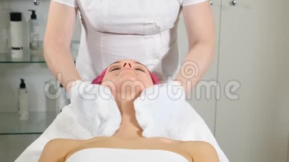 美容诊所年轻女人有专业的面部手术美容师用一个美容师给女性客户敷面膜视频的预览图