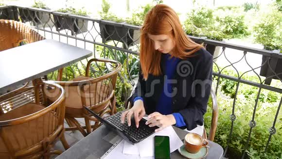 年轻迷人的商务女性在咖啡馆里使用笔记本电脑和带有绿色屏幕的手机文件和咖啡杯视频的预览图