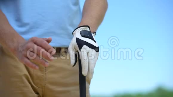 有经验的男子高尔夫球手戴着白色手套手持铁棍准备进行体育比赛视频的预览图