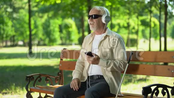 戴耳机听音频簿的盲人老人手机里的语音信息视频的预览图