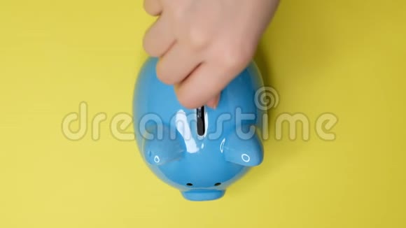 小猪银行生意一只手把硬币放在黄色背景上的储蓄罐里存钱是一种投资视频的预览图