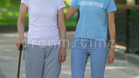 志愿者和带手杖的老年妇女一起在医院公园放松视频的预览图