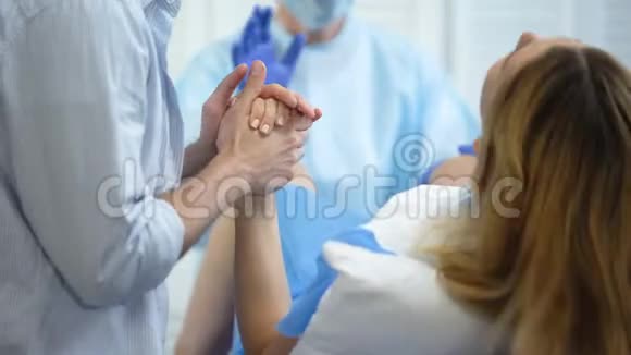 在分娩过程中男人牵着妻子的手寻求支持视频的预览图