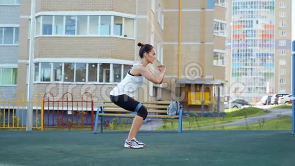房子院子里邋遢的女人从事健身用橡胶用橡皮向侧面行走的蹲视频的预览图