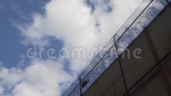 高高的监狱栅栏带着带刺的铁丝用云彩抵着天空视频的预览图