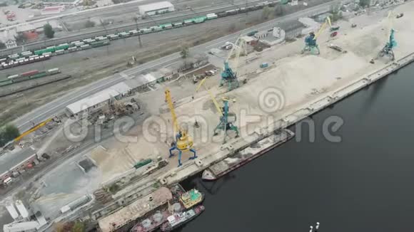 一堆沙子和货物工作起重机与挖掘机移动河沙在码头带有货车和货车的城市工业部分视频的预览图