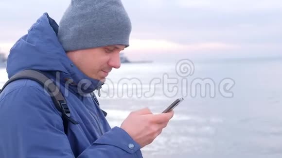 冬天人类正在沿海小镇的智能手机上输入信息侧视视频的预览图