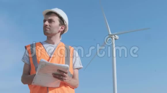 一名男工程师在风力涡轮机中填写一个领域的文件用复印机检查风力涡轮机的概念视频的预览图