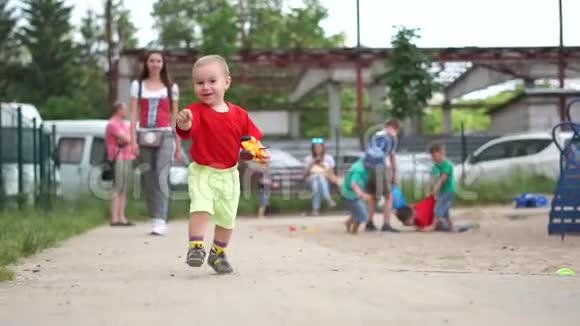 一个小男孩带着一辆破玩具车快乐地慢悠悠地跑着视频的预览图
