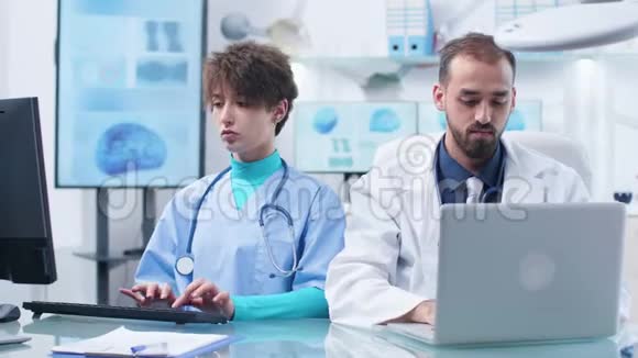 白人医生和年轻护士在同一张桌子上工作视频的预览图