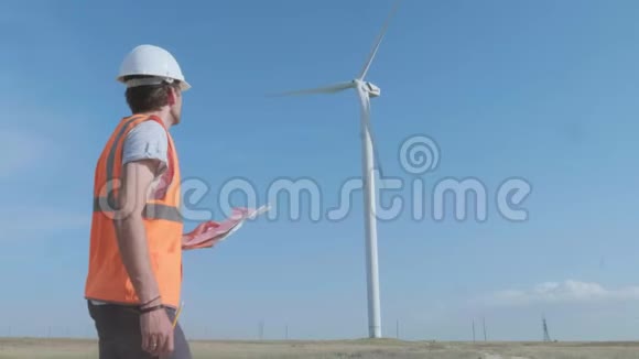 一名男工程师在风力涡轮机中填写一个领域的文件用复印机检查风力涡轮机的概念视频的预览图