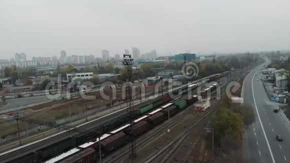 通过工业火车站和火车轨道在城市用货车和油箱运输货物的长途货运列车视频的预览图