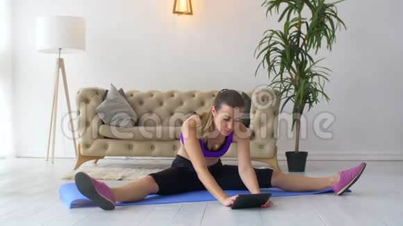 健身女性锻炼看平板电脑教程视频的预览图