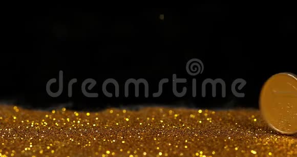 黑色背景下金色粉末滚压1欧元硬币慢动作视频的预览图