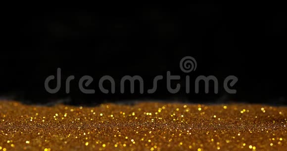 黑色背景下金色粉末滚压1欧元硬币慢动作视频的预览图