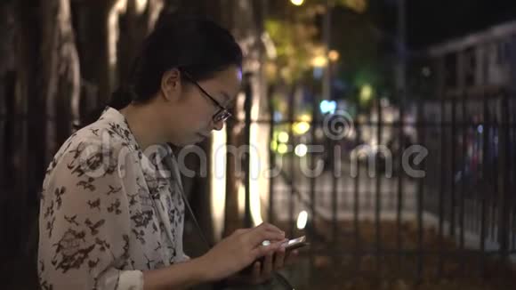 在游客座位区使用免费无线网络连接智能手机的戴眼镜的亚洲妇女视频的预览图