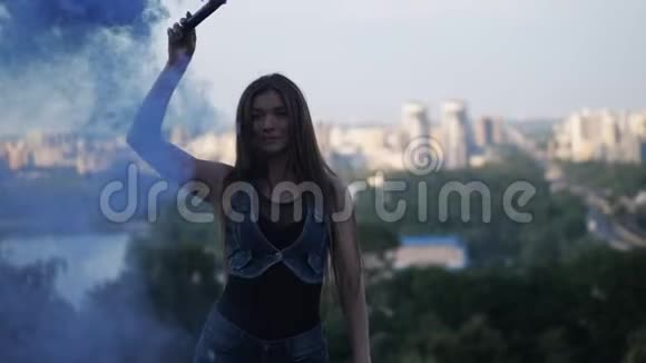 一个留着长发的时髦女孩在蓝烟的公园里跳舞4K慢慢视频的预览图