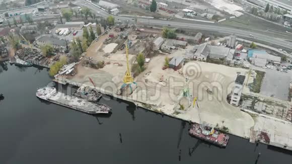 鸟瞰城市工业部分的货物起重机和一堆沙子与驳船停在河岸工业视频的预览图