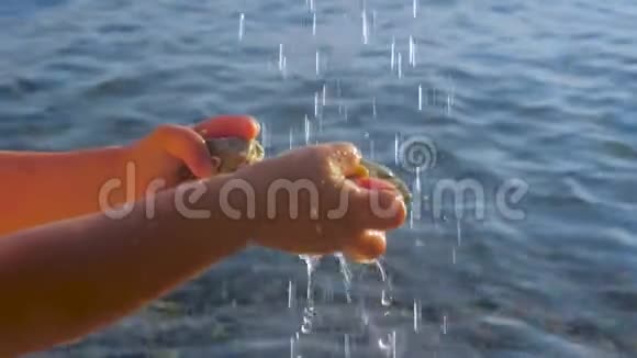欧洲炎热的夏日孩子他的手在水滴下背景是海洋纯净水背景水视频的预览图