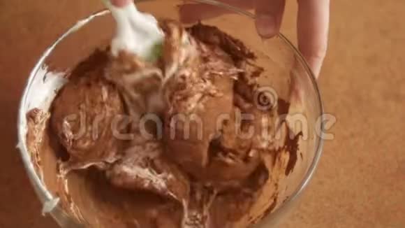 一位女厨师手在一个深玻璃碗里揉捏奶油和可可用来制作巧克力奶油用来烘焙一种视频的预览图