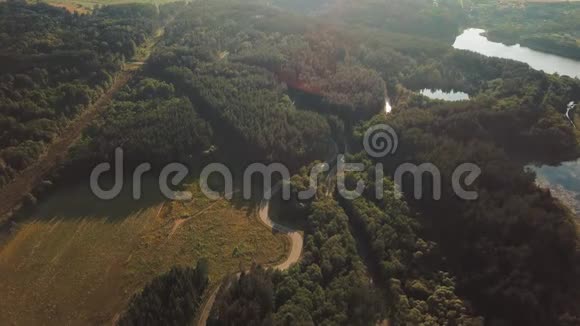 在一个明亮的夏日和接下来的一条道路上旋转空中全景景观视频的几个被森林包围的湖泊视频的预览图