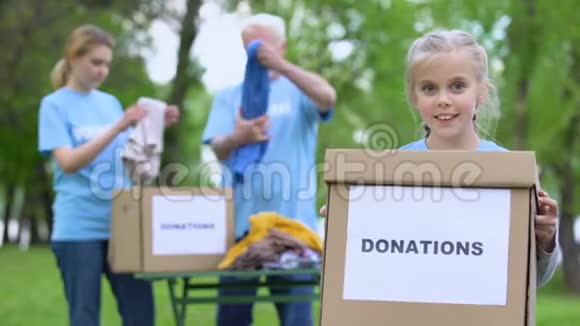 微笑的女孩拿着捐款箱志愿者准备人道主义援助帮助视频的预览图