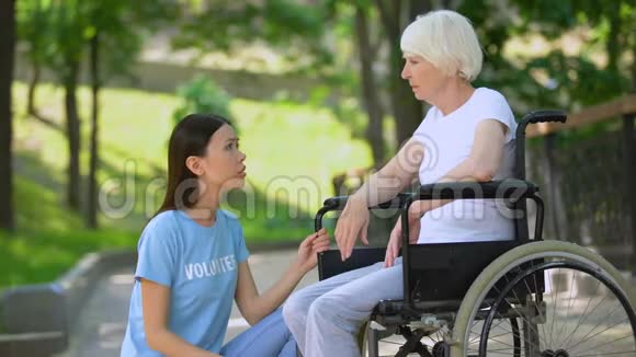 女志愿者安慰哭哭啼啼的老太太轮椅老年残疾帮助视频的预览图
