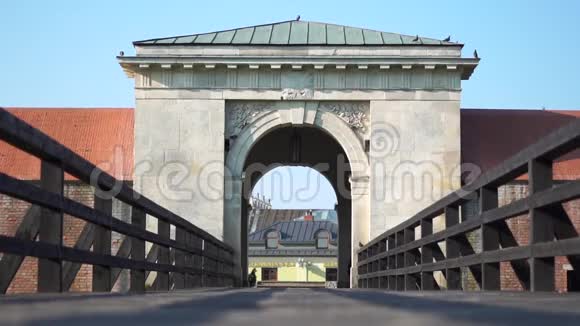 通往鸽子飞翔的老城的大门和桥红色汽车靠近大门视频的预览图