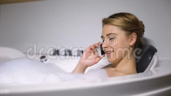 调情的女人说着电话享受着泡沫泡浴视频的预览图