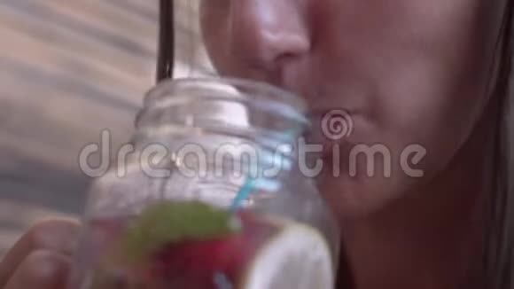 一个有趣的女孩喝着吸管的鸡尾酒在咖啡馆喝鸡尾酒的美女视频的预览图