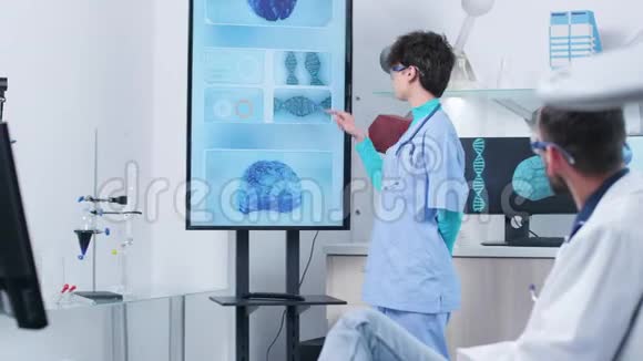 年轻护士拥有现代研究设施的高级医生视频的预览图