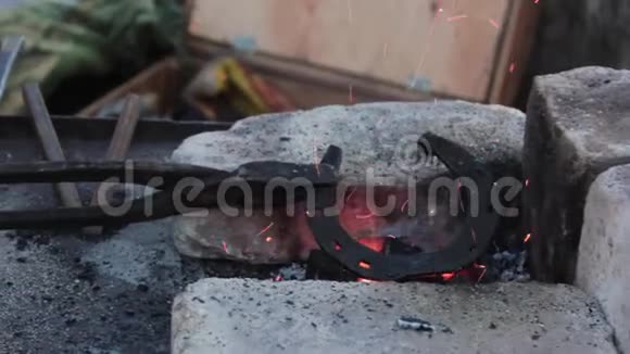 一位年轻的金属匠在工厂里加热马蹄铁的后视镜视频的预览图