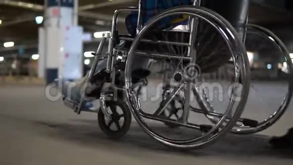 轮椅乘坐底部视图一个女人带着一个残疾人坐轮椅车轮紧贴着视频的预览图