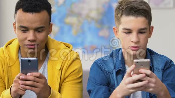 两个高中生在智能手机上浏览约会应用选择女友视频的预览图