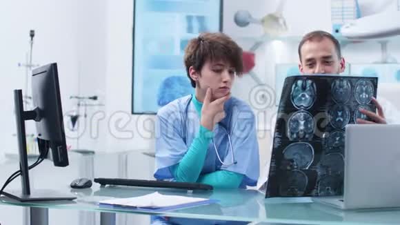 白种人医生和年轻护士分析核磁共振扫描视频的预览图