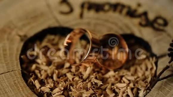 结婚仪式用木制背景装饰的金色结婚戒指视频的预览图