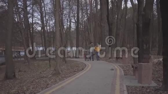 年轻的一对游客背着背包沿着公园的小路走着那个人带着自行车视频的预览图