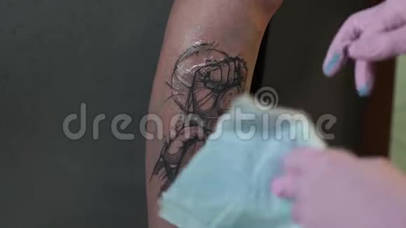 纹身师在纹身店用敷料包扎纹身的皮肤视频的预览图
