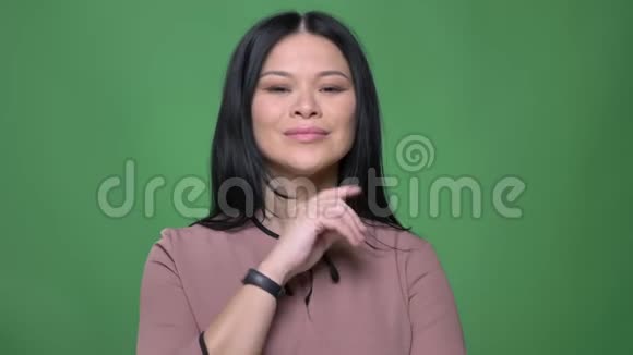 年轻迷人的亚洲女性特写镜头黑发直视镜头微笑着摆姿势视频的预览图