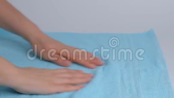 双手特写把一叠新的浴巾放在床单上客房服务员清洁酒店客房视频的预览图