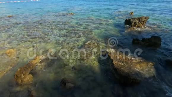 美丽的碧蓝色波浪在海面上背景海浪被海岸上的大石头冲刷背景视频的预览图