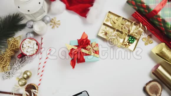 女士双手拍照圣诞礼物在白色桌子上铬键手机显示视频的预览图