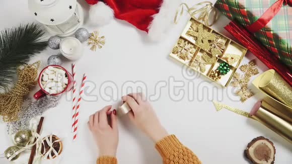 妇女剪彩包装圣诞礼物的俯视图视频的预览图