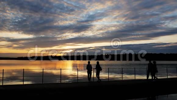 傍晚日落时分游客们在湖上的一座桥上漫步视频的预览图